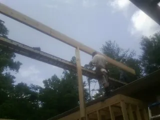 Carpenter setting a ridge beam over a new addition frame — Ice Dam Removal by Roofing Brothers in Antrim