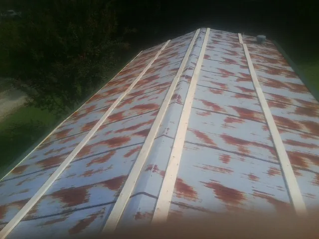 Rusted metal roof panels with new wood purlins before replacement — Storm Damage Roof Repair in Antrim by Roofing Brothers