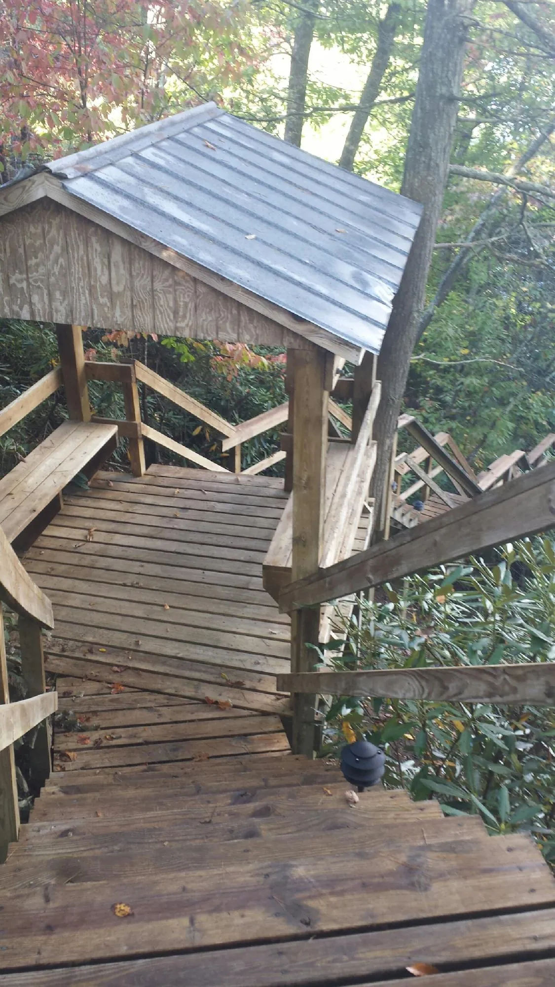 Metal roofed shelter over wooden steps on a wooded walkway — Skylight Repair & Installation work by our crew in Antrim