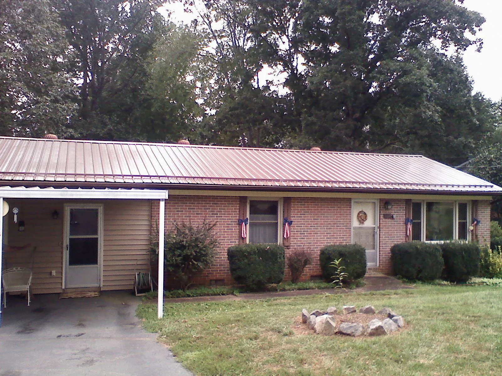 Bronze metal roof and carport on a brick ranch home — Roof Repair work by our crew in Antrim